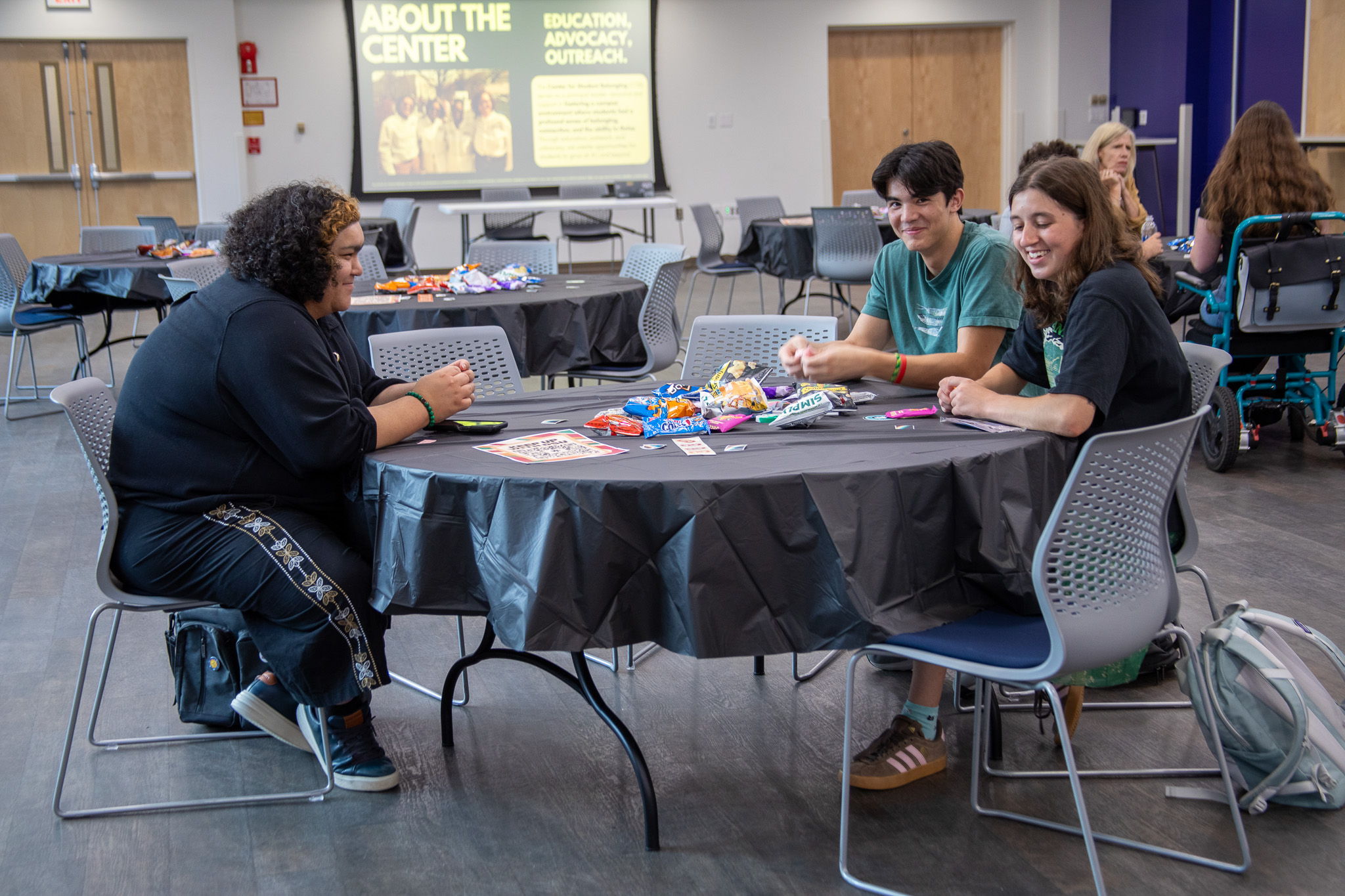 Three students sit around a table at the Disability Connection Social.