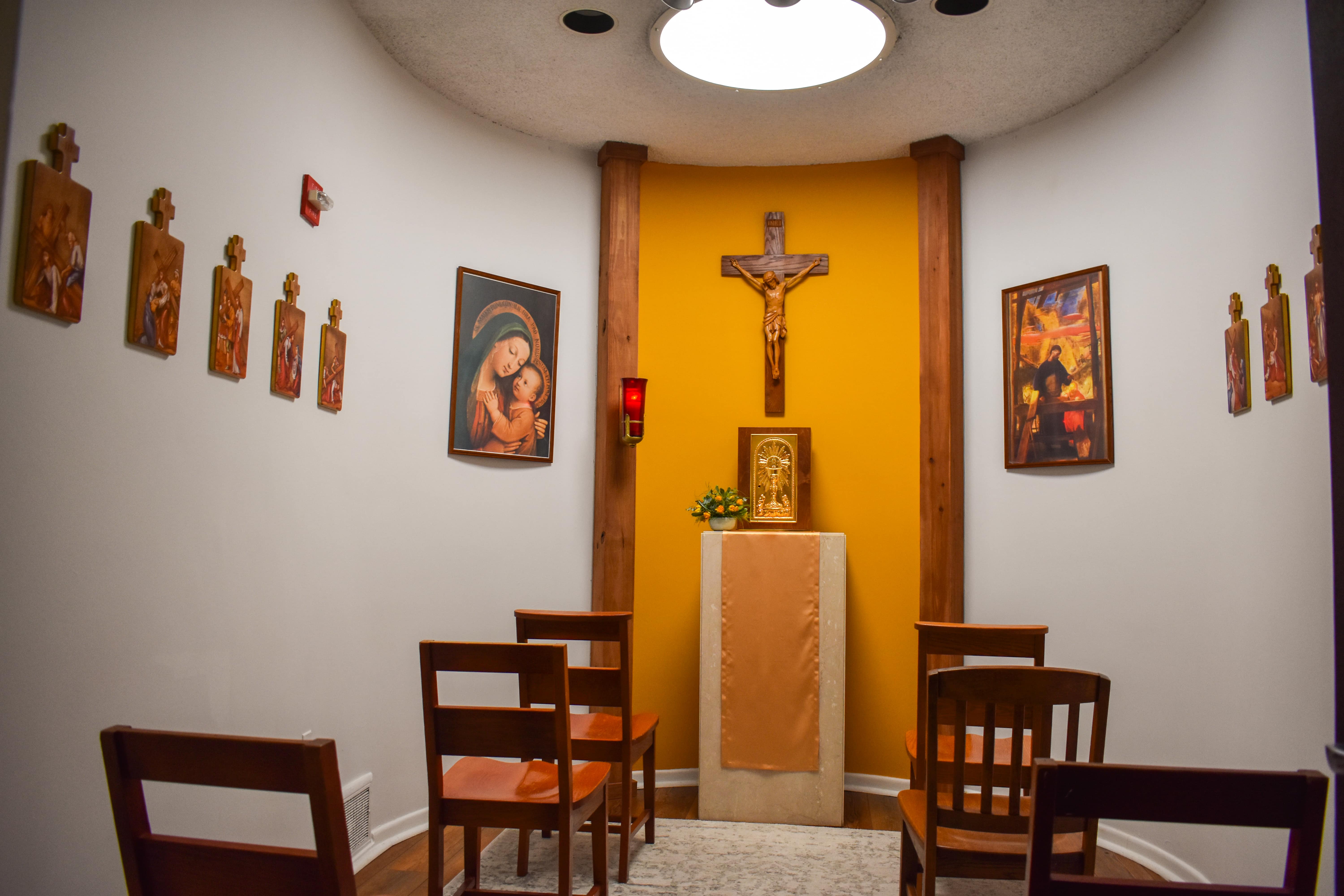 A Catholic Chapel in Kay Spiritual Life Center, several chairs face a cross and image of Mary holding an infant Jesus.