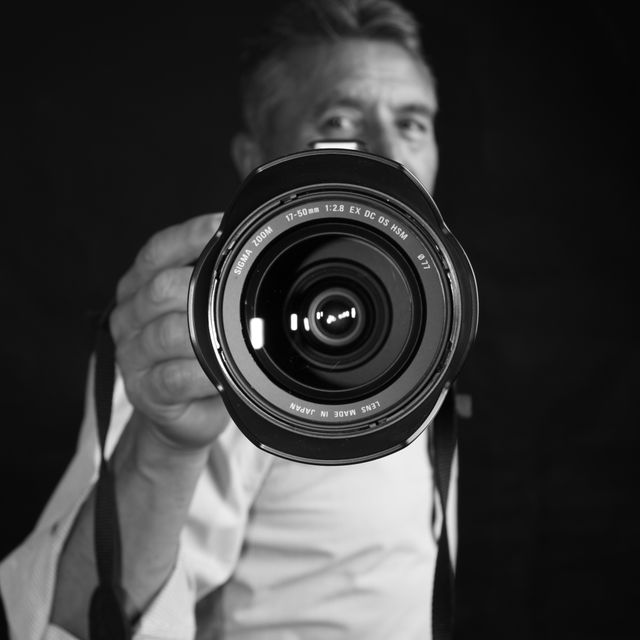 BW Photographer Stylish black and white photo showcasing a close-up view of a camera lens.