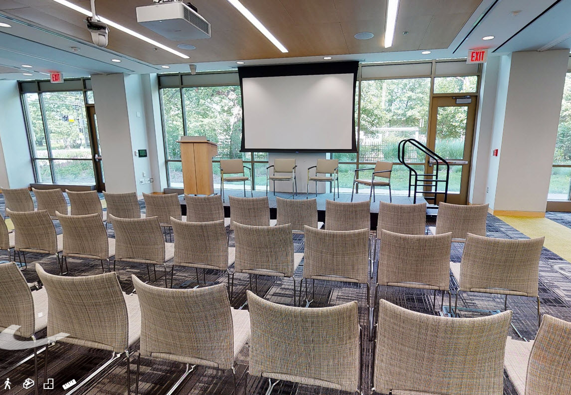 Meeting Room with rows of chairs and a stage with podium and projector screen in front