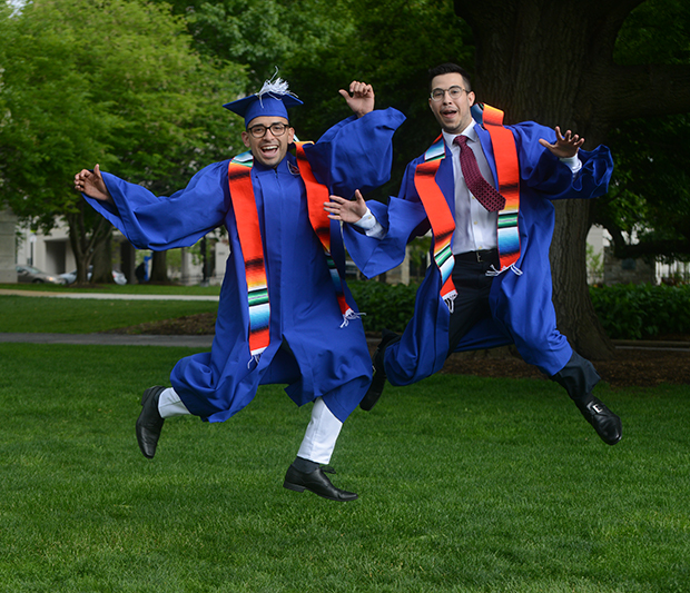 Two Happy Graduates Jumping Outside