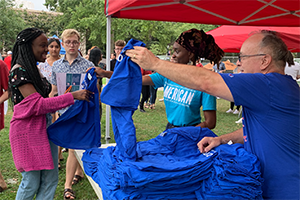 Alumni volunteers hand out t-shirts to new students