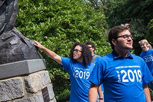 a student touches an Eagle statue