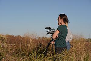 Women filming in a field