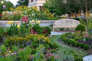 Flowers and cultivated plants next to a bench, right near the School of International Service building.