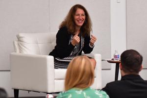 Woman sitting in white chair and smiling