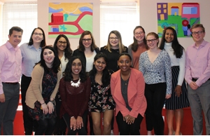 Students pose before colorful artwork at the Latin American Youth Center.