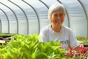 Farmer standing in greenhouse with plants