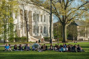 A group of students sit on the quad during  a peer mentor meeting.