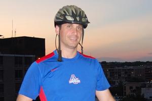 Man with his bike helmet and sporty AU shirt.