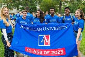Students wearing blue shirts, holding banner