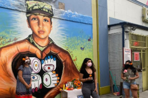 Three women in front of a DC mural honoring Vanessa Guillen