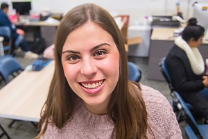 Courtney Rozen in The Eagle newsroom office. Two students are sitting in the background.