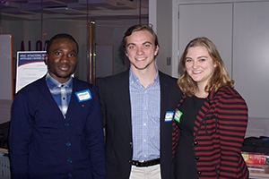 Three people in business casual and nametags stand indoors