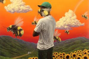 Album art from Tyler, the Creator's album Flower Boy; Man standing in a field of sunflowers surrounded by bees