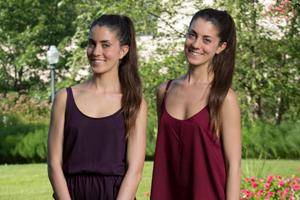 Two Argentine female students outside in front of trees and flowers.