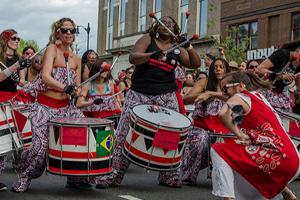 Batalá Washington, playing at the Funk Parade. Red, green, and white drums. Vibrant scene with all-female drum unit.