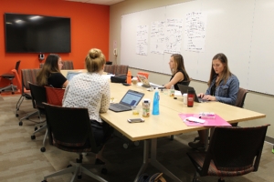 Students working and sitting around table