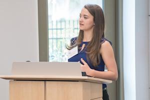 Student Irena Volkov standing at a podium addressing students at the Merit Award Breakfast.