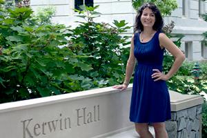 Female professor standing in front of the SPA Kerwin Hall sign.