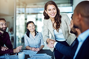 A young female professional shakes hands with executives