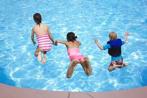 Kids jumping into a pool