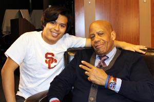 Younger student in T-shirt with professor in sweater and tie.