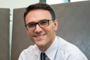 Man with dark hair and glasses.