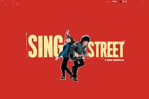 Sing Street a new musical two people on a red background, one is holding a guitar