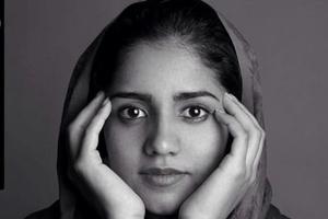 Afghan woman with her hands on her face.