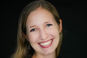 Woman wearing earrings and smiling.