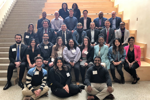 Student leaders and alumni board members sit on the large steps in the School of International Service.