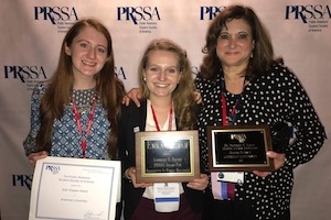 Two PRSSA members and professor Gemma Puglisi hold their award plaques