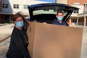 Trina and son with box filled with PPE