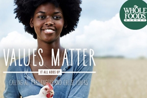 An African American woman holding a chicken from Whole Food's 