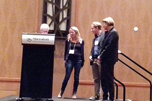 Beers and two others stand onstage at the award ceremony.