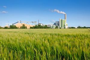 field with factory in background