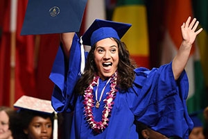 Student in cap and gown holding diploma