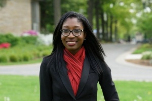 Ebunola stands outside in a red scarf.