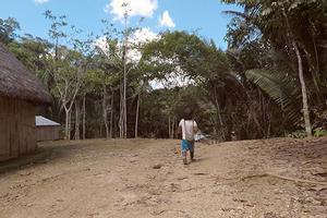 Indigenous person walking through rainforest