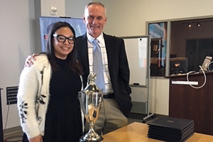 L to R Ambar Pardilla, trophy, and Rodger Streitmatter