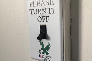 Light switch with a sticker that reads,