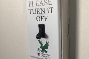 Light switch with a sticker that reads, 