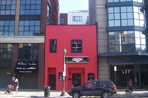 A red house is sandwiched between new development projects in Washington, D.C.