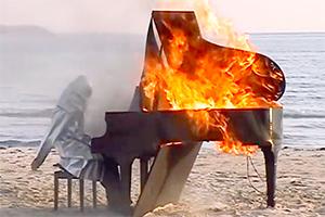 photograph of piano burning on beach