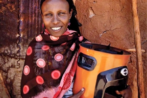 Kenyan woman holding a wood-burning stove