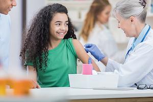 A child gets their arm swabbed by a physician