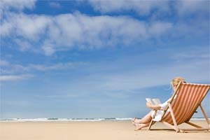 Person sitting on the beach reading a book