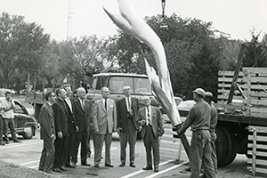 Men review the Kay Center’s 14 foot bronze flame before it is placed on building Men review the Kay Center’s 14 foot bronze flame before it is placed on building