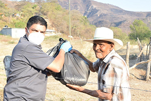 Man hands bag of donated food to another man